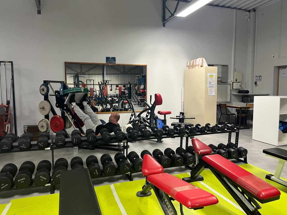 Râteliers d'haltères et bancs réglables rouges de la salle SGHM à Guérande